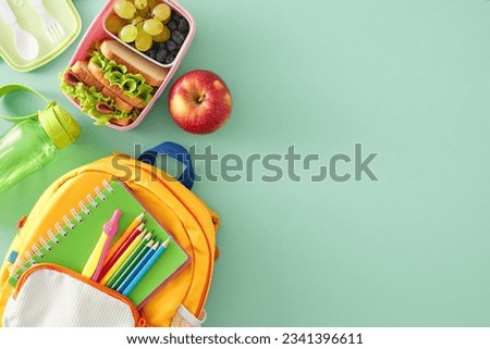 Balanced school meal idea. Top view photo of lunchbox filled with sandwiches and fresh snacks, cutlery, plastic bottle, stationery, rucksack on turquoise background with blank space for advert or text Royalty-Free Stock Photo #2341396611