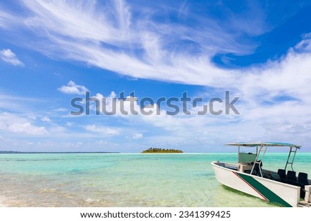boat and picture perfect island with surrounding turquoise lagoon