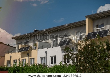 Panorama view of townhouses with with solar power plant on a balconies with sunlight reflection and special lens flare light effect. Balcony solar power station eco-friendly to use renewable energy. 