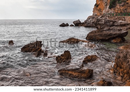 Rocky coast of sea in cloudy weather . Rock in the sea Royalty-Free Stock Photo #2341411899