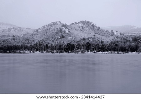 Patagonia winter landscape. Long exposure shot of the Andes mountains, forest and Alumine lake early in the morning. Royalty-Free Stock Photo #2341414427