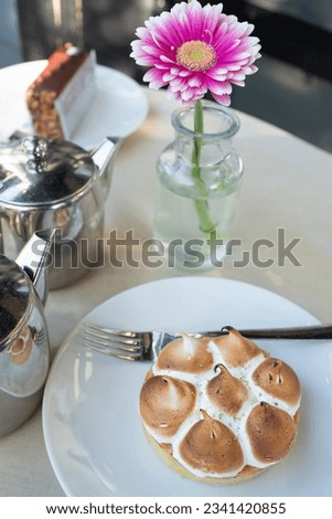 Cutlery set, Summer time vibe, morning breakfast with delicious dessert. Composition of a Pink flower in vase and plate with cake on the table. Still life