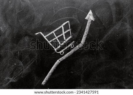 Inflation concept, arrow and shopping cart painted on a blackboard with chalk