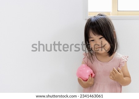 A smiling girl with a piggy bank (2 years and 11 months, Japanese)