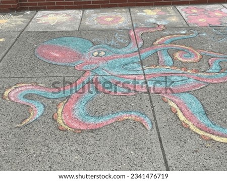 Octopus drawn with sidewalk chalk along a busy Main Street.