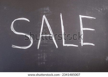 Inscription "Sale" is written on blackboard. 