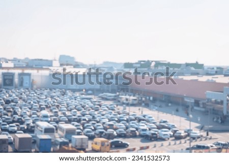 Blurred view of full parking lots next mall complex, outdoor. Uncovered crowded parking modern shopping center, bokeh light, retail store, for abstract background