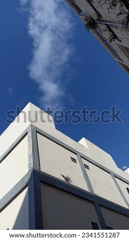 Photo of a building exposed to sunlight and a blue sky
