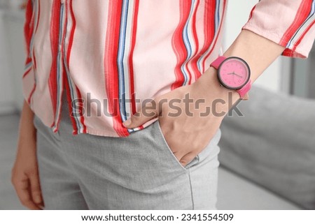 Young woman with stylish wristwatch in room, closeup