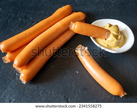 boiled sausages served with mustard on black slate