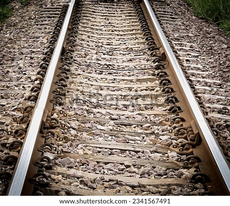 a photography of a train track with a bunch of rocks on it, there is a train track that has been laid out with rocks on it.