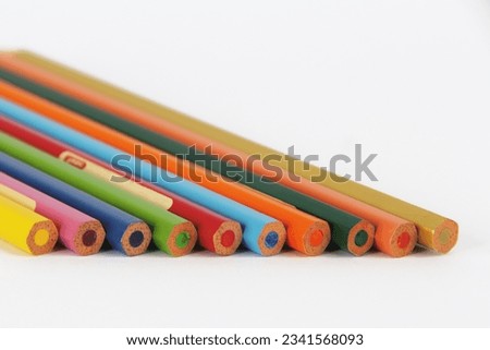 Neatly arranged colored pencils against a white background
