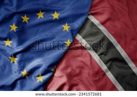 big waving realistic national colorful flag of european union and national flag of trinidad and tobago . macro