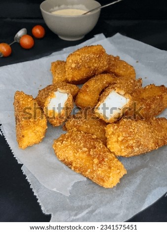 Homemade fish nuggets on grease proof paper with a dark background Royalty-Free Stock Photo #2341575451