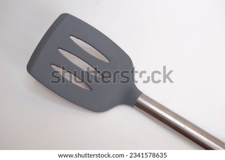 (Top of View) Gray spatula made of rubber and stainless handle isolated on white background Royalty-Free Stock Photo #2341578635