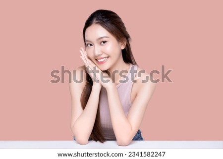 Beautiful young Asian woman with healthy and perfect skin on isolated pink background. Facial and skin care concept for commercial advertising.