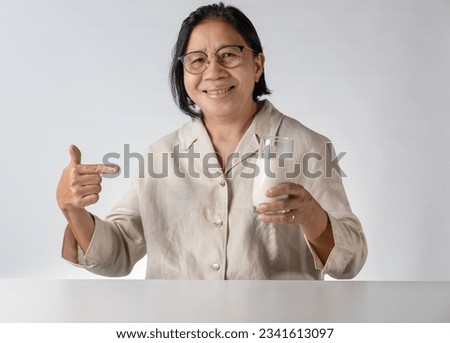 Asian senior woman drinking milk happily