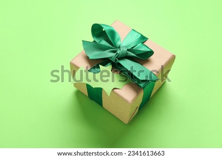 Beautiful gift box and bat made of paper for Halloween on green background, closeup