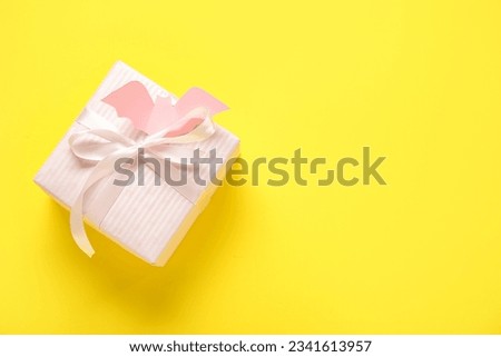 Beautiful gift box and bat made of paper for Halloween on yellow background