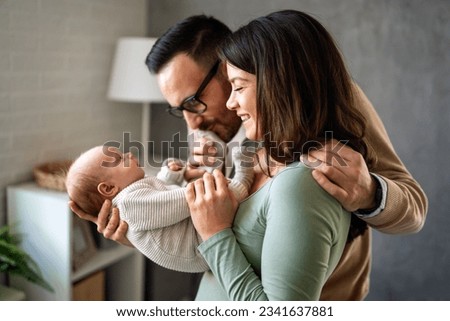 Proud mother and father smiling at their newborn baby daughter, son at home Royalty-Free Stock Photo #2341637881