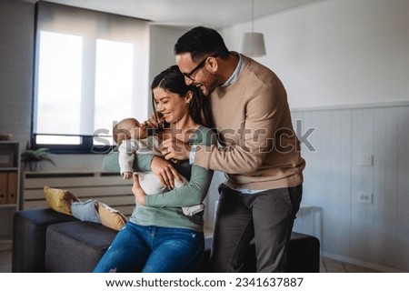 Peaceful young married couple enjoying being family, parents, holding new born baby in arms Royalty-Free Stock Photo #2341637887