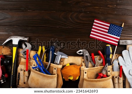 Labor day banner mockup of tools toolbelt and us flag on wooden background Royalty-Free Stock Photo #2341642693