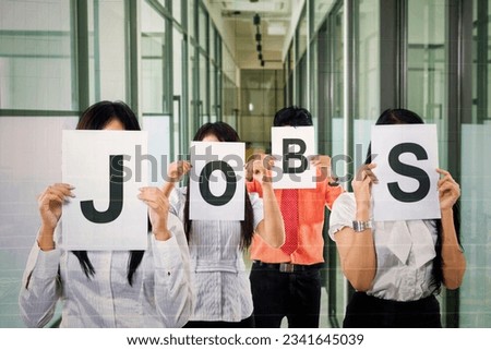 Group of business people covering their face with JOBS writing on papers Royalty-Free Stock Photo #2341645039