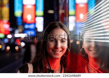 Young beautiful girl walking in Times Square at night. New York City, Manhattan