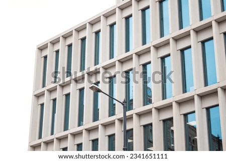 Strict geometric facade of massive concrete blocks, blue-tinted glass