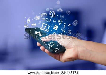 Hand holding smartphone with media icons and symbol collection Royalty-Free Stock Photo #234165178