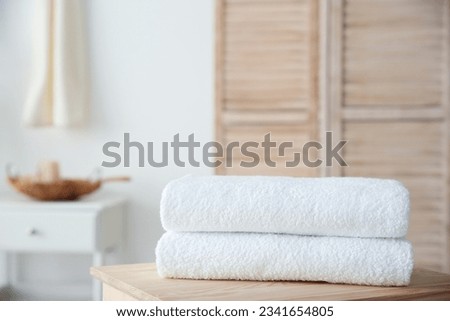 Stack of towels on table against blurred background Royalty-Free Stock Photo #2341654805