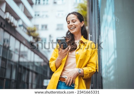 Shot of a beautiful mature businesswoman texting. Mature businesswoman walking outdoors and using cellphone. Female business professional walking outside and texting from her mobile phone.