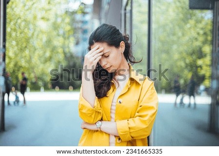 Dizzy woman complaining in the street. Young woman standing suffering for headache at street. Woman standing with eyes closed and head in hands on street Royalty-Free Stock Photo #2341665335