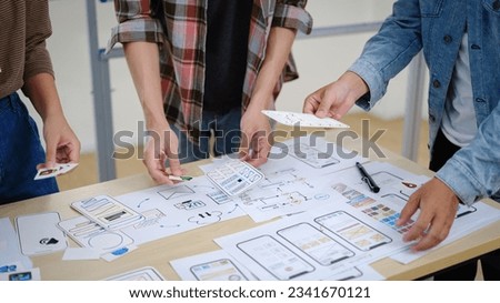 Group of young creative people working on new website wireframe, planning application development at office. Royalty-Free Stock Photo #2341670121