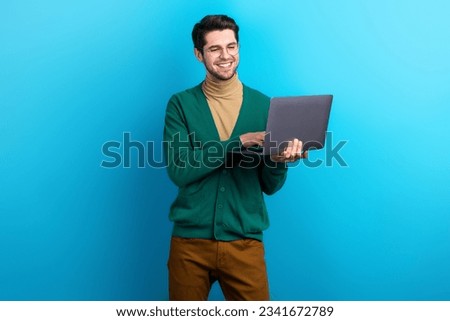 Photo of cheerful charming guy dressed green cardigan eyewear working modern gadget isolated blue color background