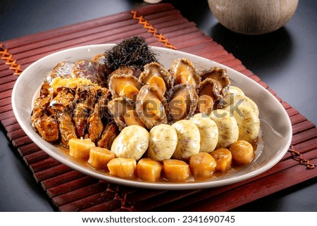 traditional asian luxury treasure premium seafood Peng cai abalone, sea cucumber, scallop, prawn, oyster, mushroom in hot clay pot on red table for Chinese new year cuisine halal banquet food menu Royalty-Free Stock Photo #2341690745