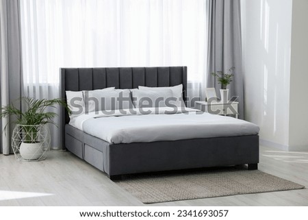 Stylish bedroom interior with comfortable bed and beautiful houseplants Royalty-Free Stock Photo #2341693057