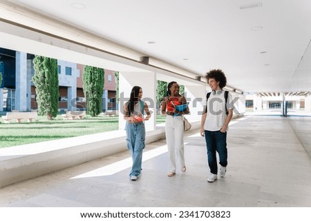 Group of young teenagers going back to school. Student friends walking through the university talking and laughing. Royalty-Free Stock Photo #2341703823