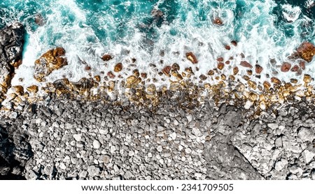 Aerial shot stony volcanic beach, drone point of view breaking waves of Atlantic Ocean, surf at sunny summer day. Sao Miguel, Ponta Delgada island. Azores, Portugal Royalty-Free Stock Photo #2341709505