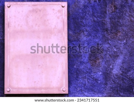 Pink plaque with place for text on blue granite wall.