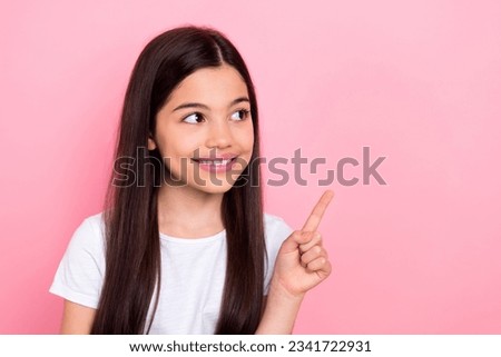 Photo portrait of adorable schoolkid female look finger point empty space promo wear trendy white outfit isolated on pink color background