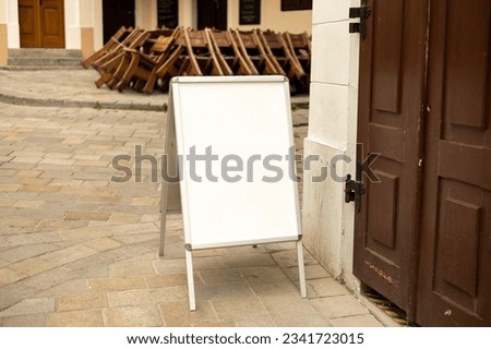 Blank outdoor white board at a sidewalk restaurants advertising. White outdoor advertising stand or sandwich board mock up template. Clear street signage board placed outdoor