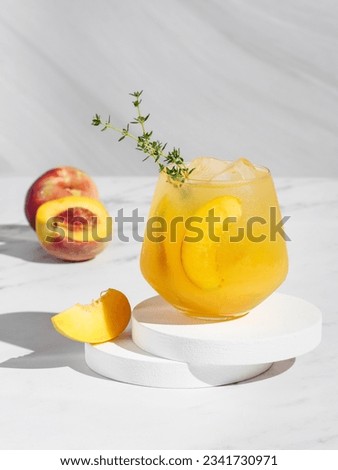 Peach thyme spritzer cocktail on a light background. Vertical photo. Copy space. hard light. Royalty-Free Stock Photo #2341730971
