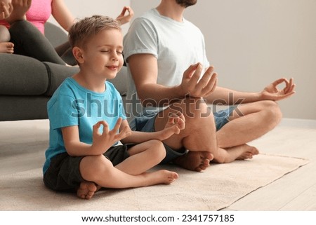 Family meditating together at home, closeup. Harmony and zen