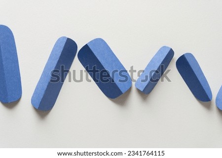 folded and cut blue paper objects arranged in chevron pattern on white
