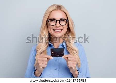 Photo of mature charming business entrepreneur lady banker holding plastic credit card new economy terms isolated on grey color background