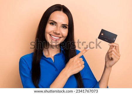 Photo of nice pretty girl beaming smile indicate finger hand hold plastic debit card isolated on beige color background