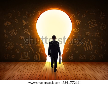 Business man looking at bright light bulb in the wall concept