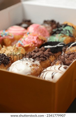 colorful donuts with various flavors on white paper boxes.  suitable as a commercial photo