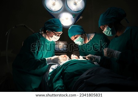 Group of concentrated surgical doctor team doing surgery patients in hospital operating theater. Professional medical team doing critical operations Royalty-Free Stock Photo #2341805831